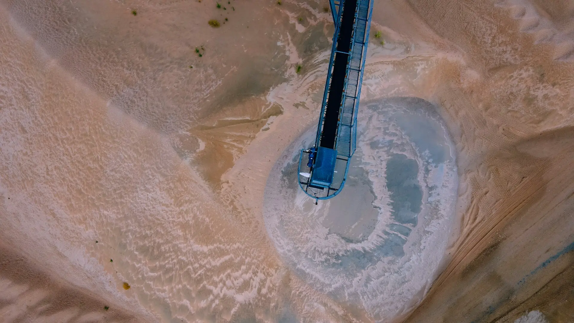 a blue and white rocket on a dirt road